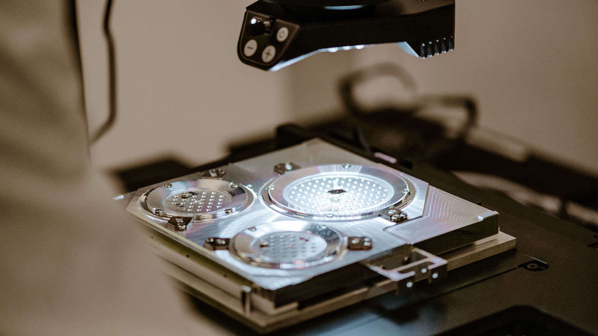 A patterned wafer carrier illuminated under an inspection microscope in the Birck Nanotechnology Center.