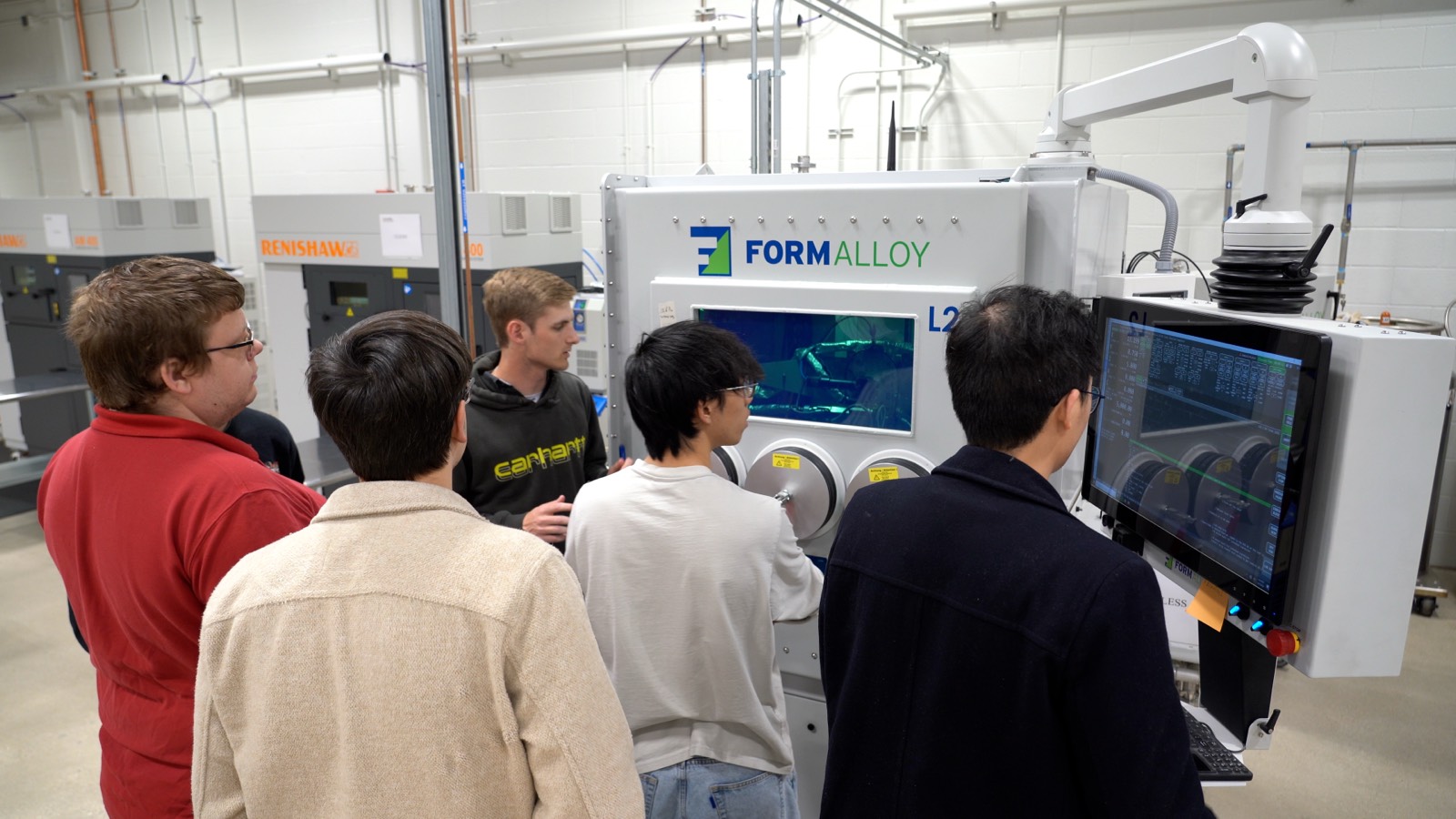 Researchers at MMRL gathered around a directed-energy-deposition additive manufacturing cell.